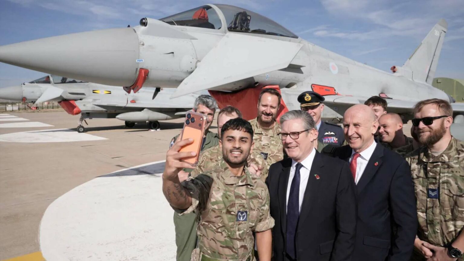 رئيس الوزراء البريطاني كير ستارمر ووزير الدفاع جون هيلي يلتقطان صورة سيلفي مع أفراد من القوات المسلحة البريطانية أمام طائرة «تايفون» مقاتلة بريطانية في قاعدة توساس الجوية في أنقرة.