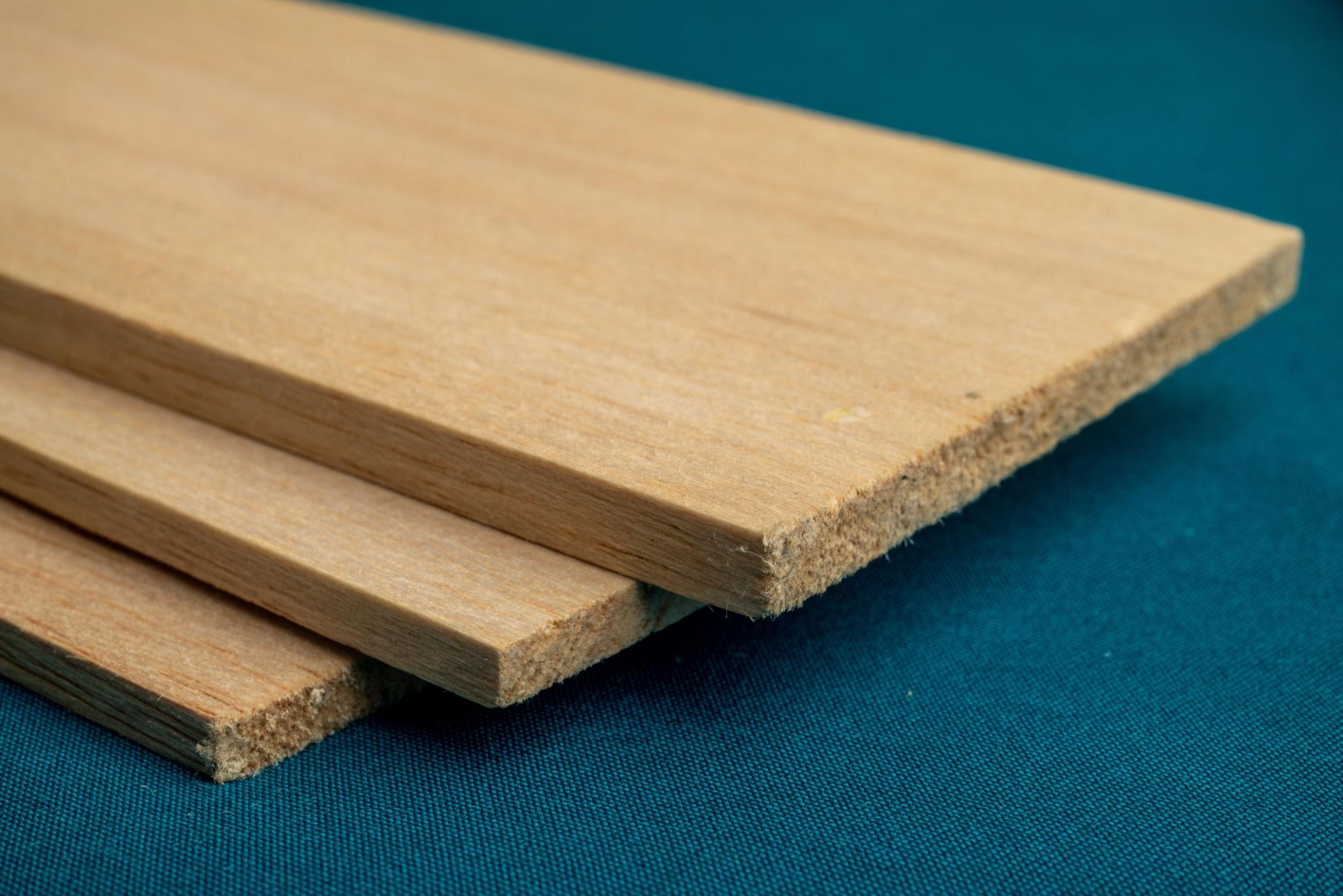 خشب البلسا. ثلاث قطع خفيفة الوزن من خشب البلسا بنقوش على خلفية خضراء.